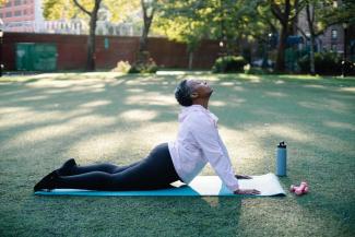 Elderly woman doing yoga in a park